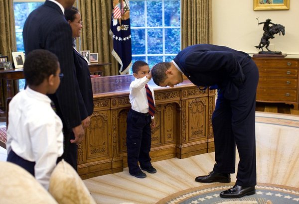 Un enfant touche la tête de Barack Obama
